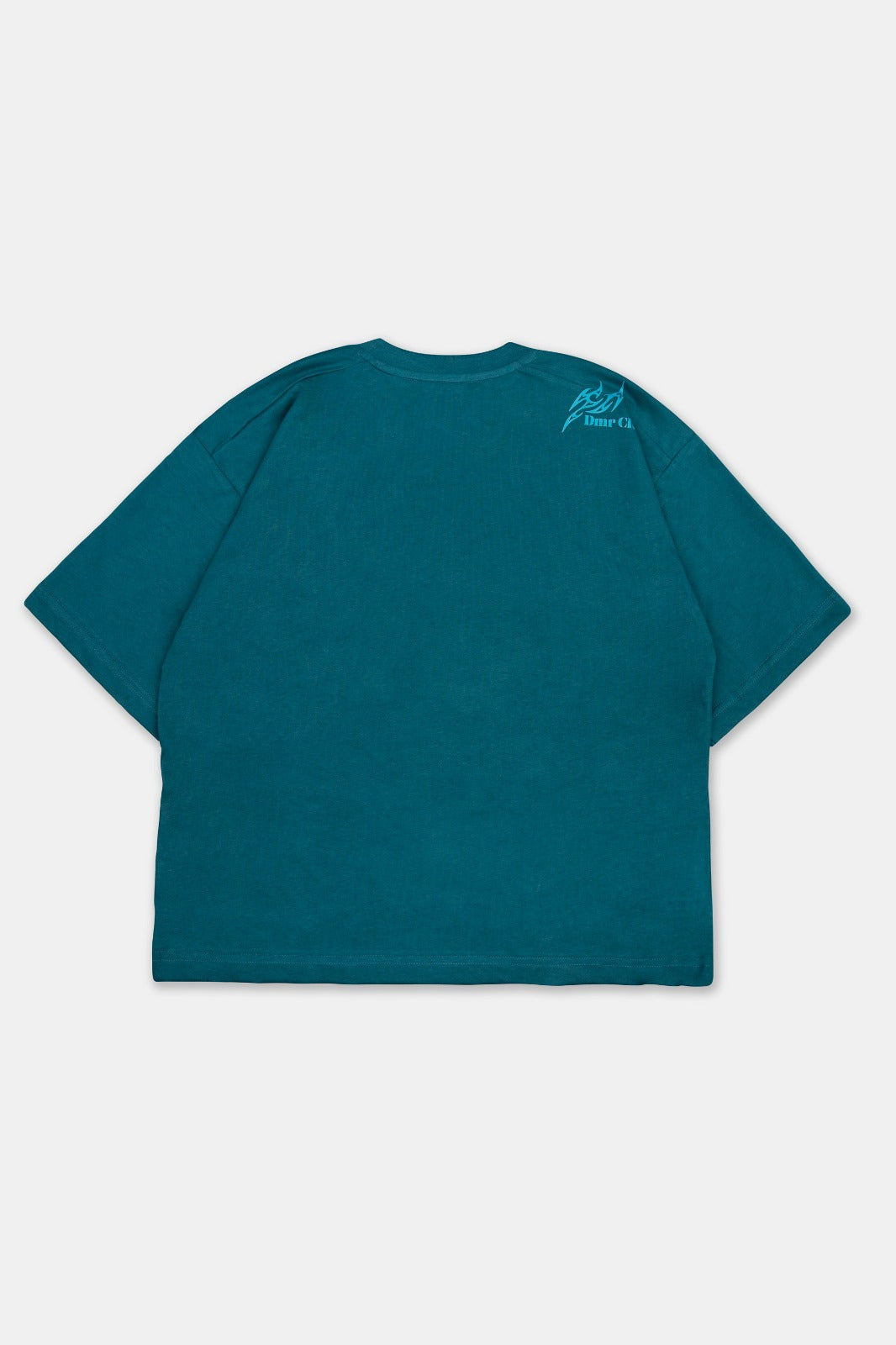 Vista trasera del polo boxy fit para hombre en color verde esmeralda. Con cuello redondo, manga corta y estampado DTF a la altura del hombro. 