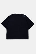 Vista trasera de polo boxy fit en color negro para hombre. Con cuello redondo, manga corta y estampado en la altura del hombro.
