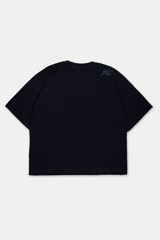Vista trasera de polo boxy fit en color negro para hombre. Con cuello redondo, manga corta y estampado en la altura del hombro.